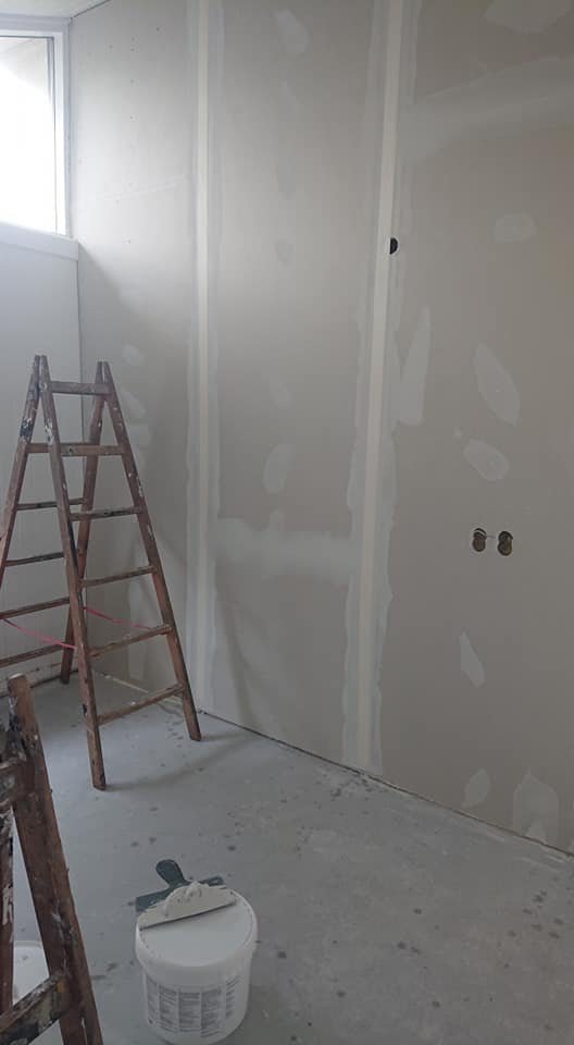 Værelse under renovering med stige og spartelmasse.