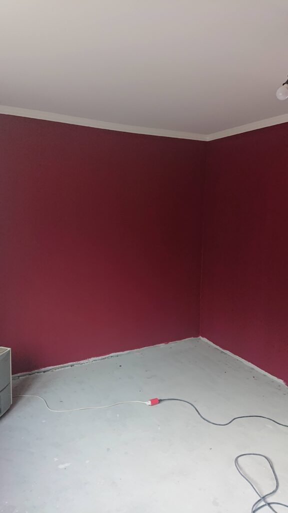 Nymalet værelse med bordeauxrøde vægge og hvid loft