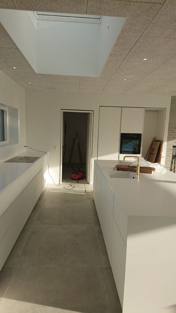 Moderne hvidt køkken med ovenlys og ø